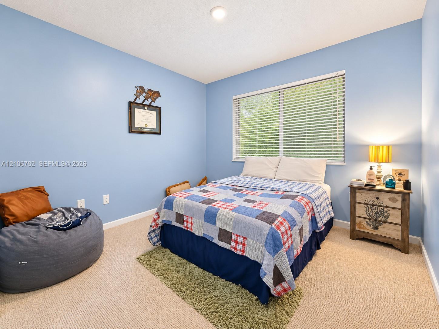 Neutral-toned wall-to-wall carpeting and a dual-pane horizontal sliding window with integrated blinds