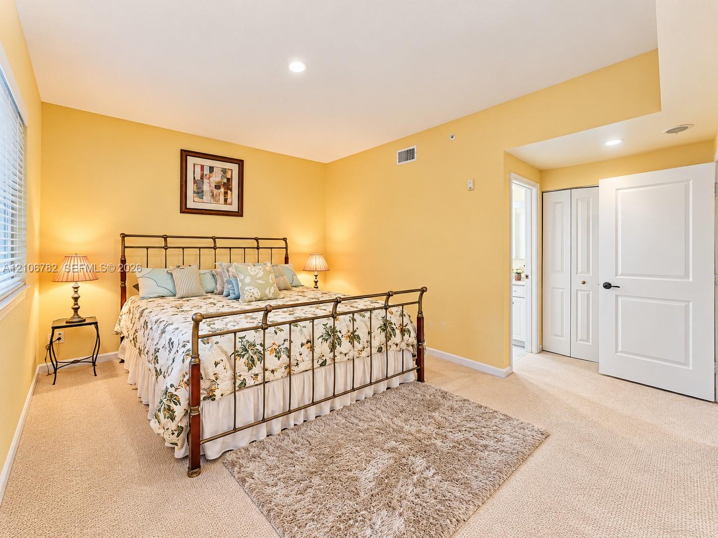 Neutral-toned carpeting, recessed ceiling lighting, bi-fold closet doors, and multi-panel interior door