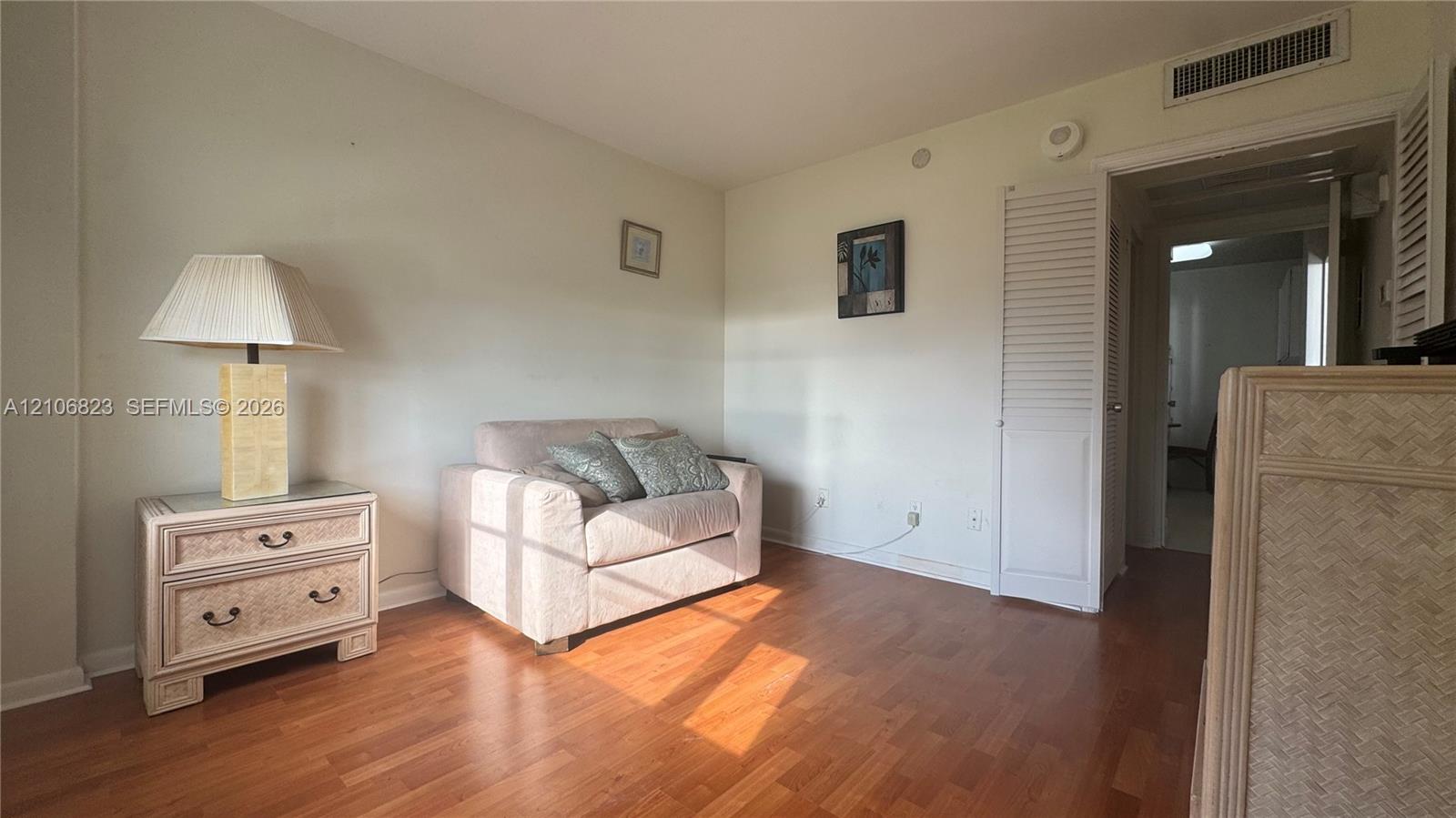 Wood-finish flooring, neutral wall tones, and louvered closet doors