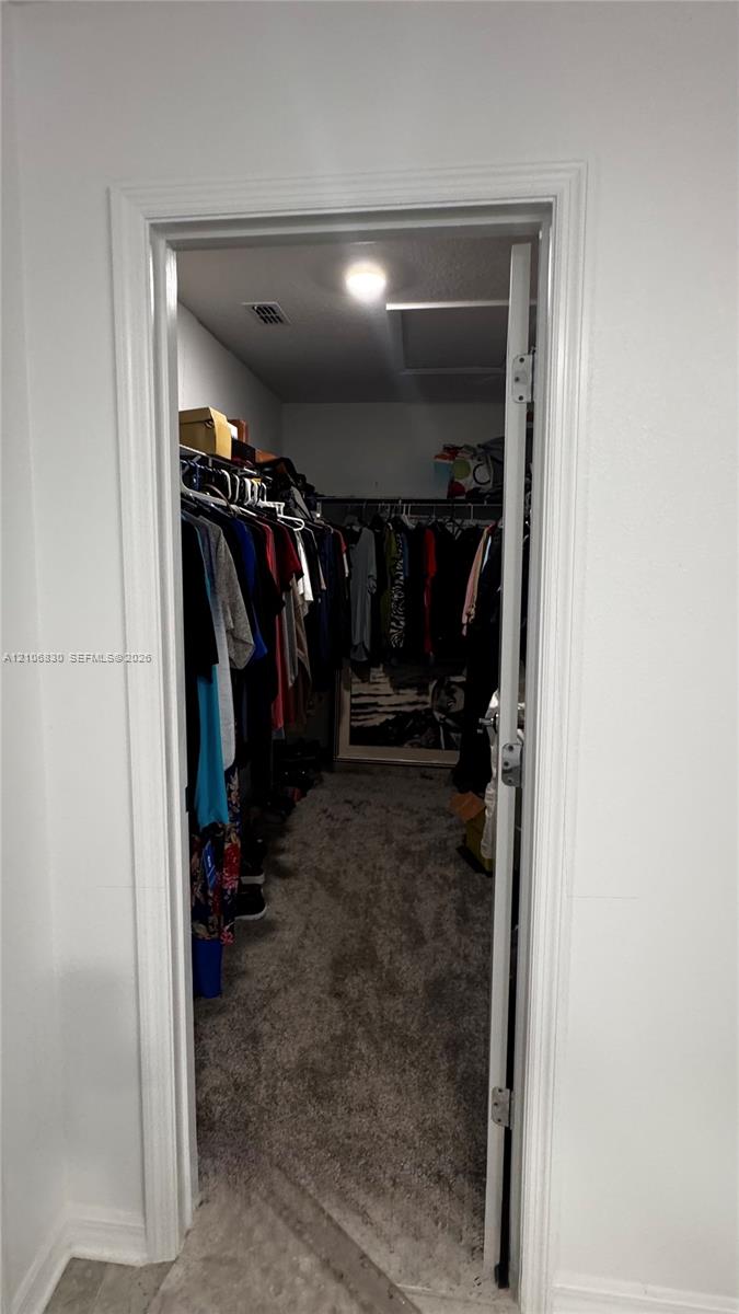 Walk-in closet featuring wall-to-wall carpeting, recessed lighting, and multi-tier wire shelving