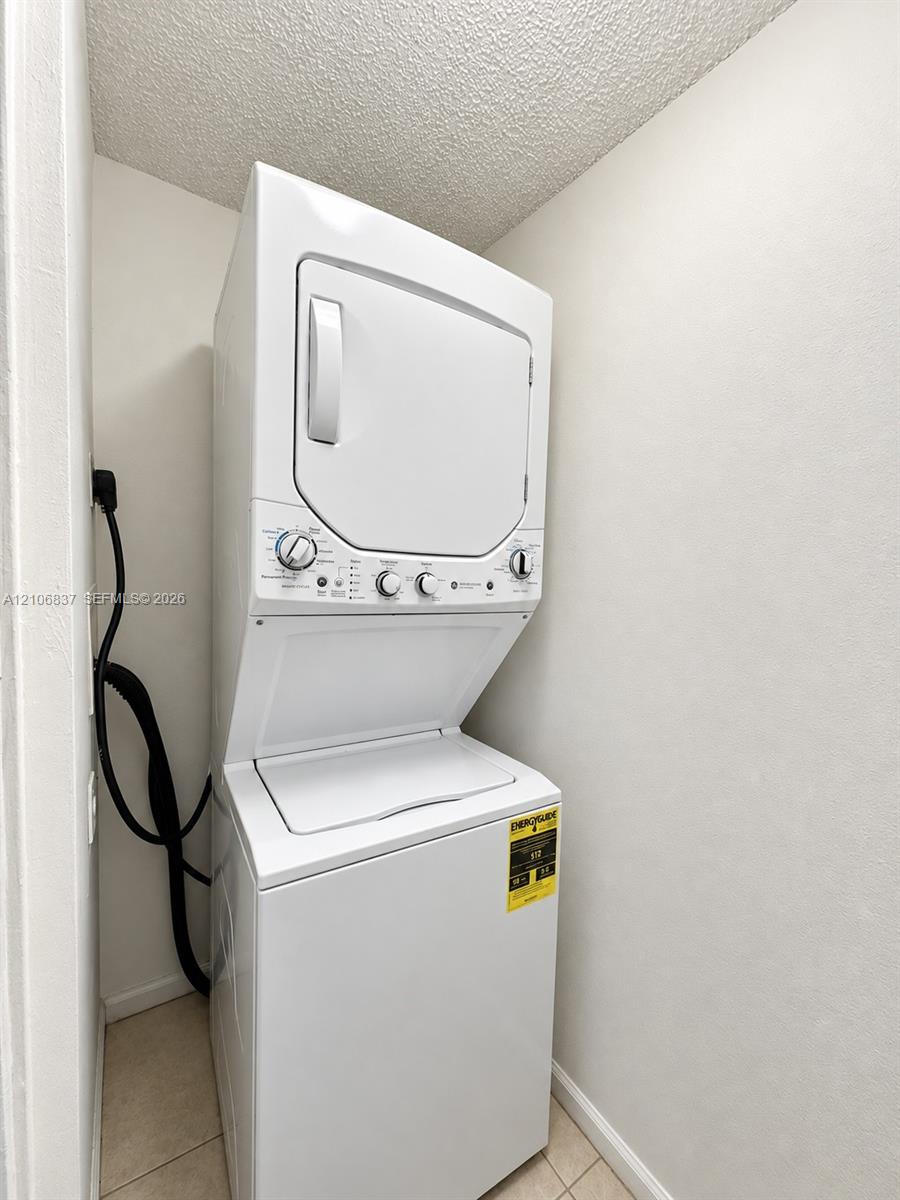 Stacked laundry unit with white finish and integrated control panel
