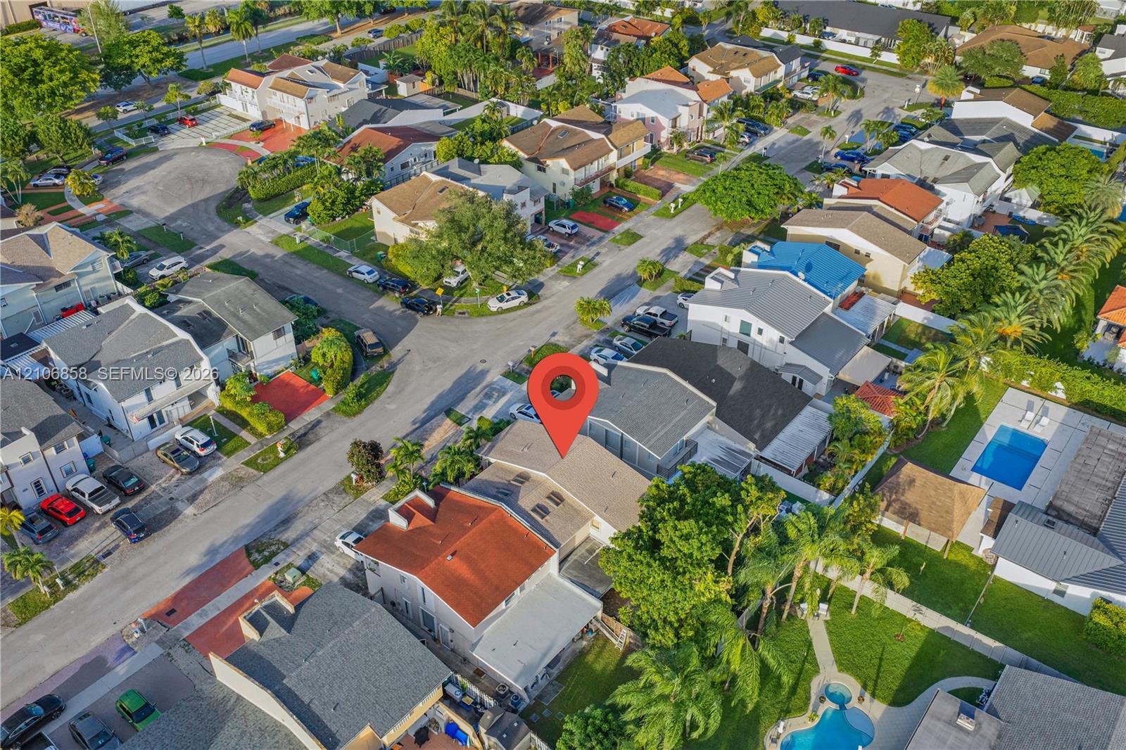 Aerial perspective of a multi-level residence featuring a pitched roof, integrated skylights, and residential street frontage within a platted subdivision