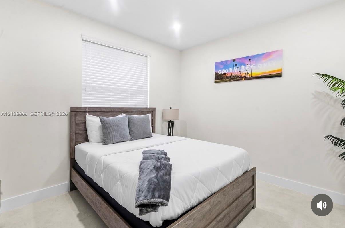 Neutral interior featuring recessed ceiling lighting, light-toned tile flooring, and a single window with horizontal blinds