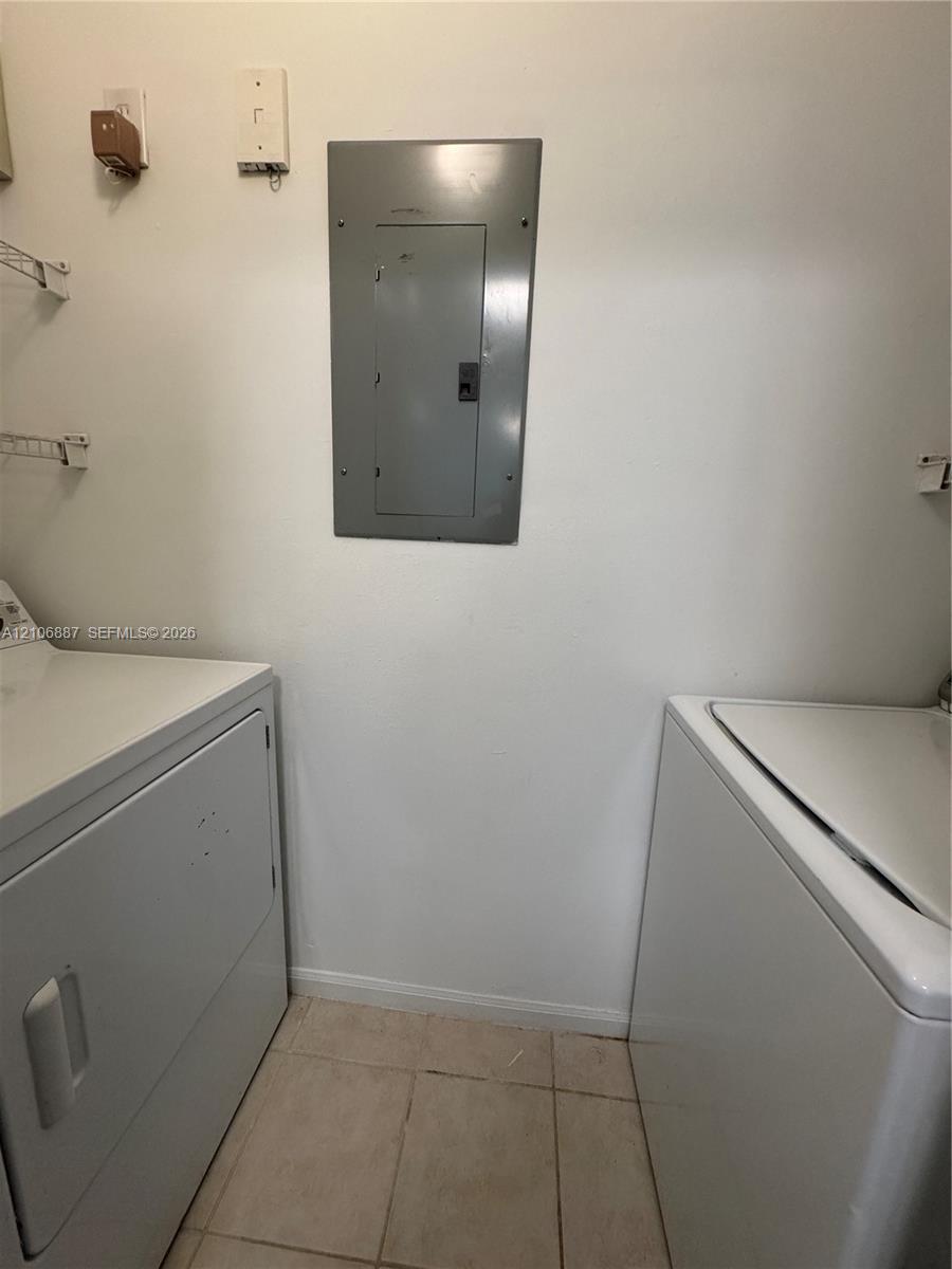Dedicated utility space featuring tile flooring and wall-mounted wire shelving
