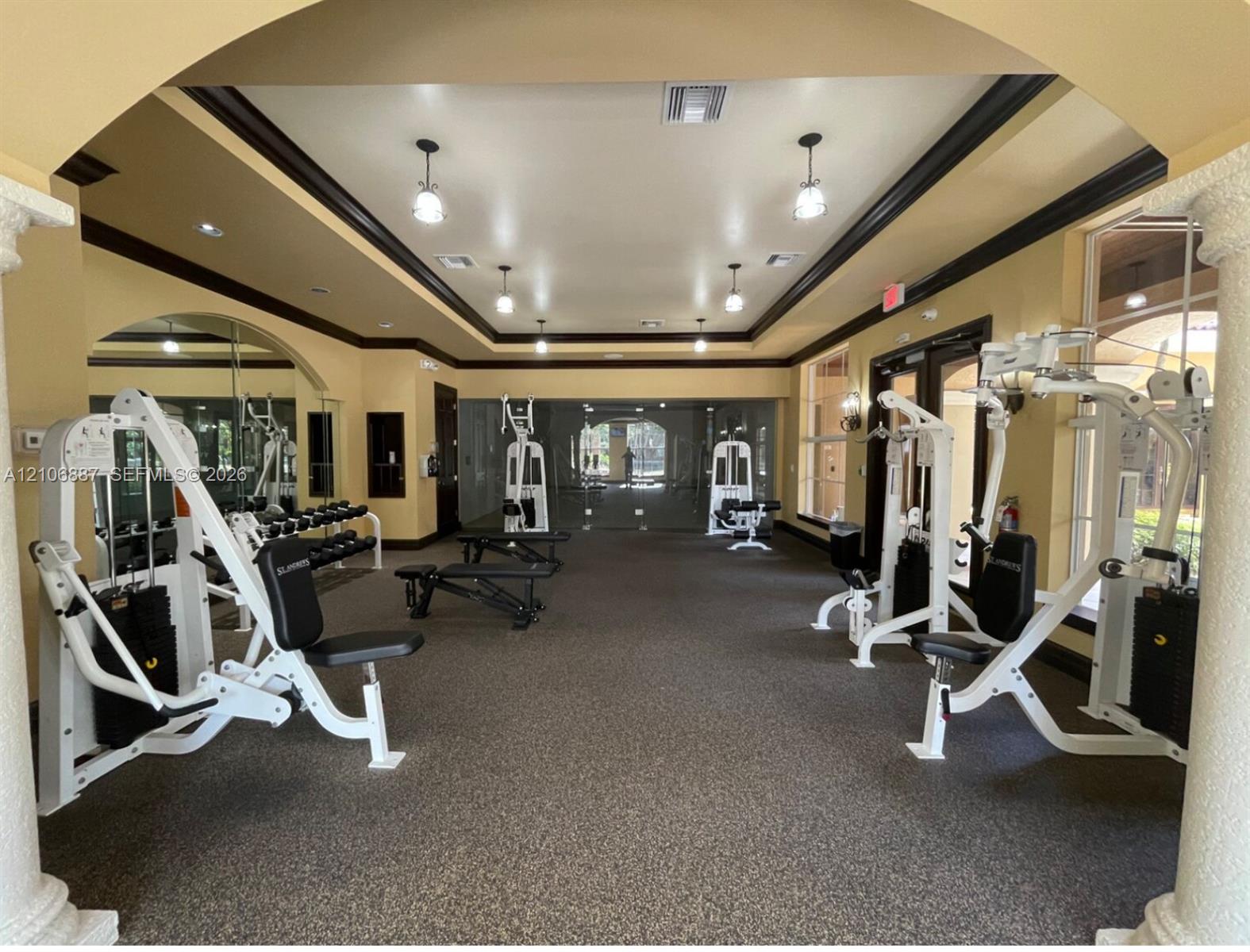 Fitness center featuring decorative columns, crown molding, recessed lighting, and wall-to-wall carpeting