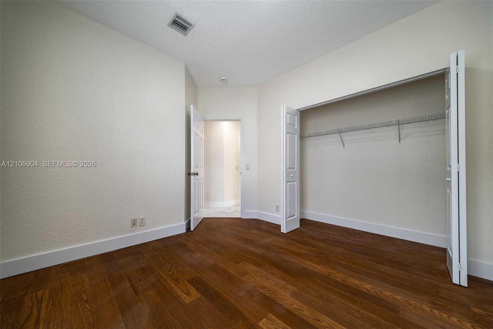 Wood-finish flooring, neutral wall tones, bi-fold closet doors, and interior paneled doors