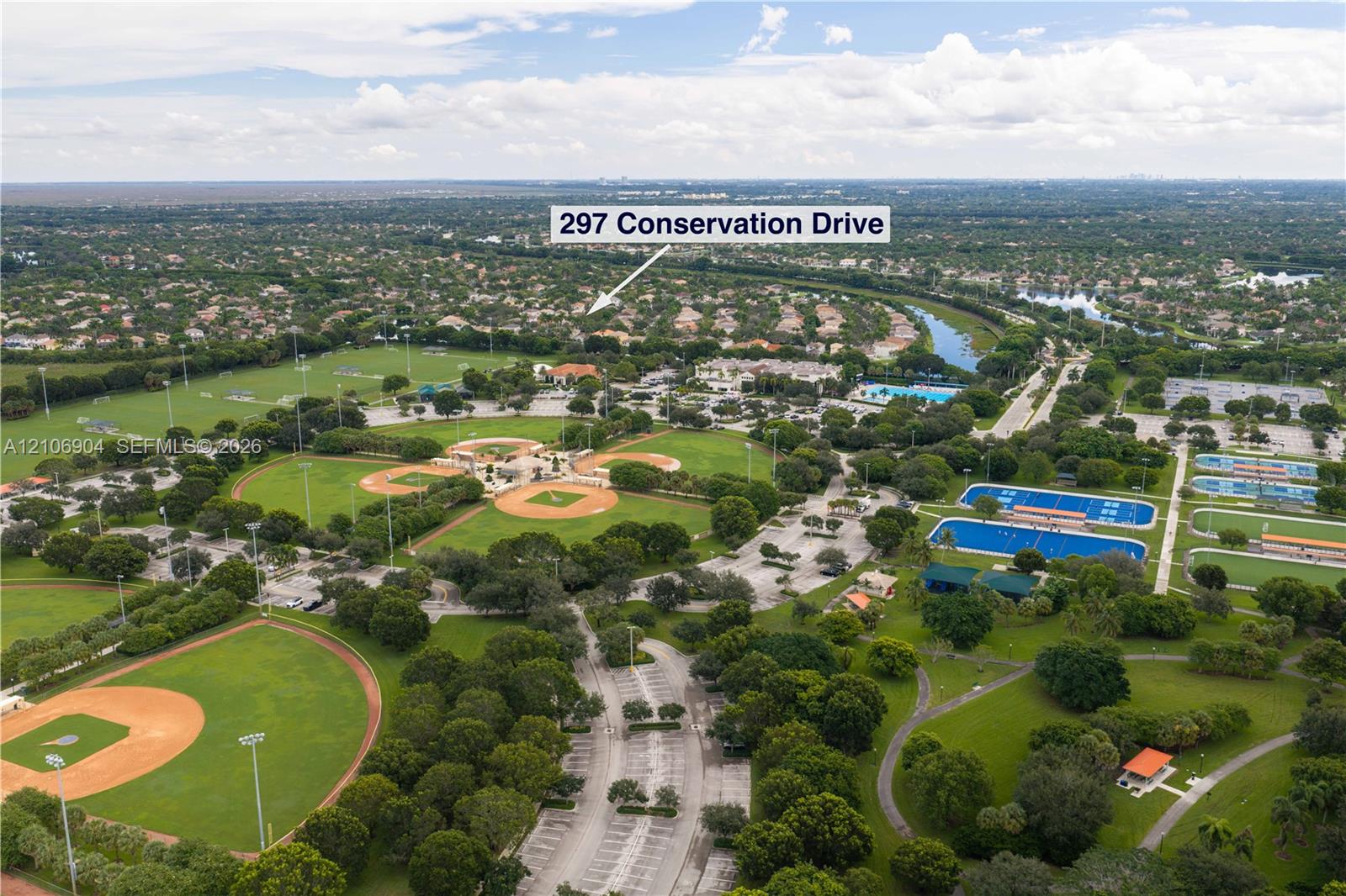 Aerial perspective showcasing proximity to recreational grounds featuring multiple baseball diamonds, tennis courts, and expansive green space