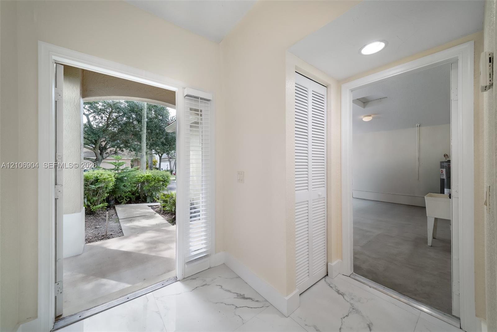 Entry featuring stone-finish tile flooring, white louvered closet doors, and recessed lighting
