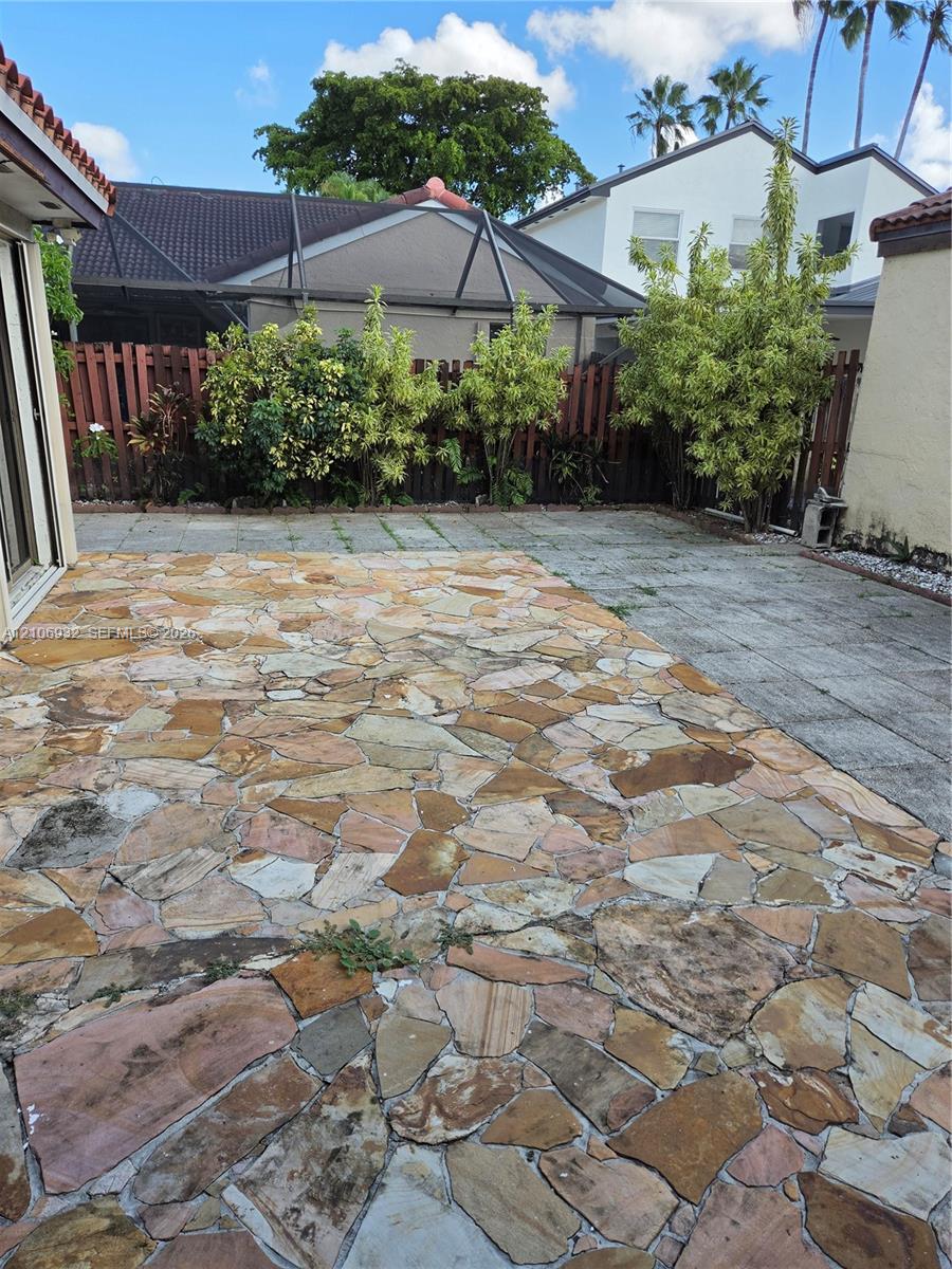 Flagstone patio featuring a concrete paved section, enclosed by wood privacy fencing and mature landscaping
