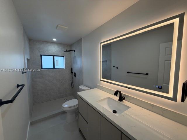 Modern bathroom featuring a modern vanity with a light-toned countertop, rectangular undermount sink, matte black faucet, and an integrated LED-lit vanity mirror