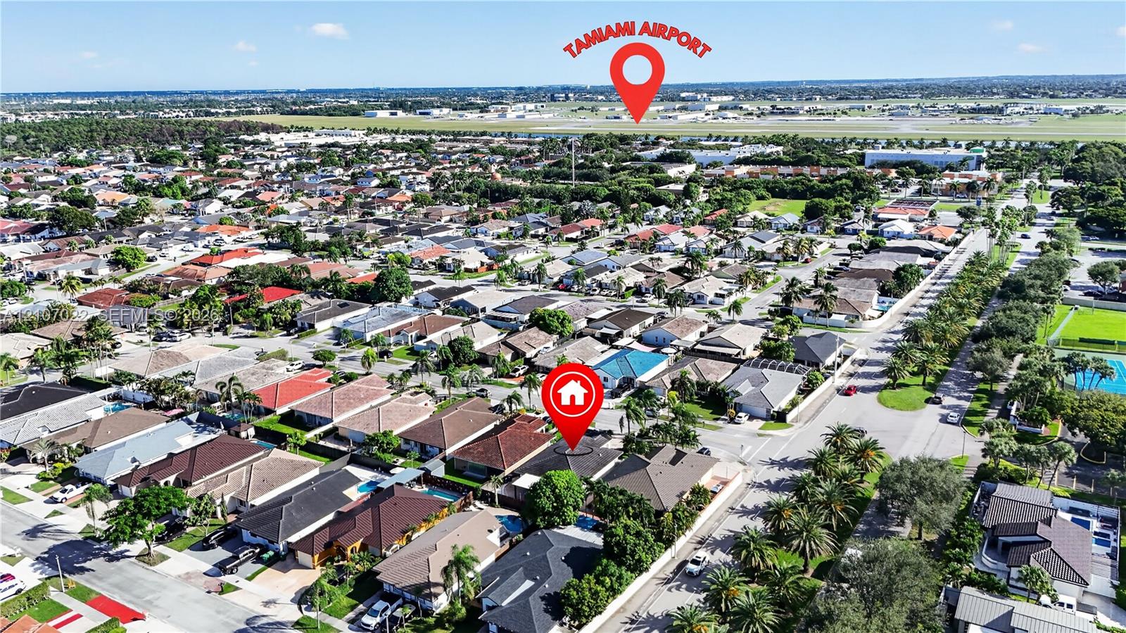 Aerial perspective of a residential neighborhood featuring paved streets, mature canopy trees, and proximity to regional aviation infrastructure