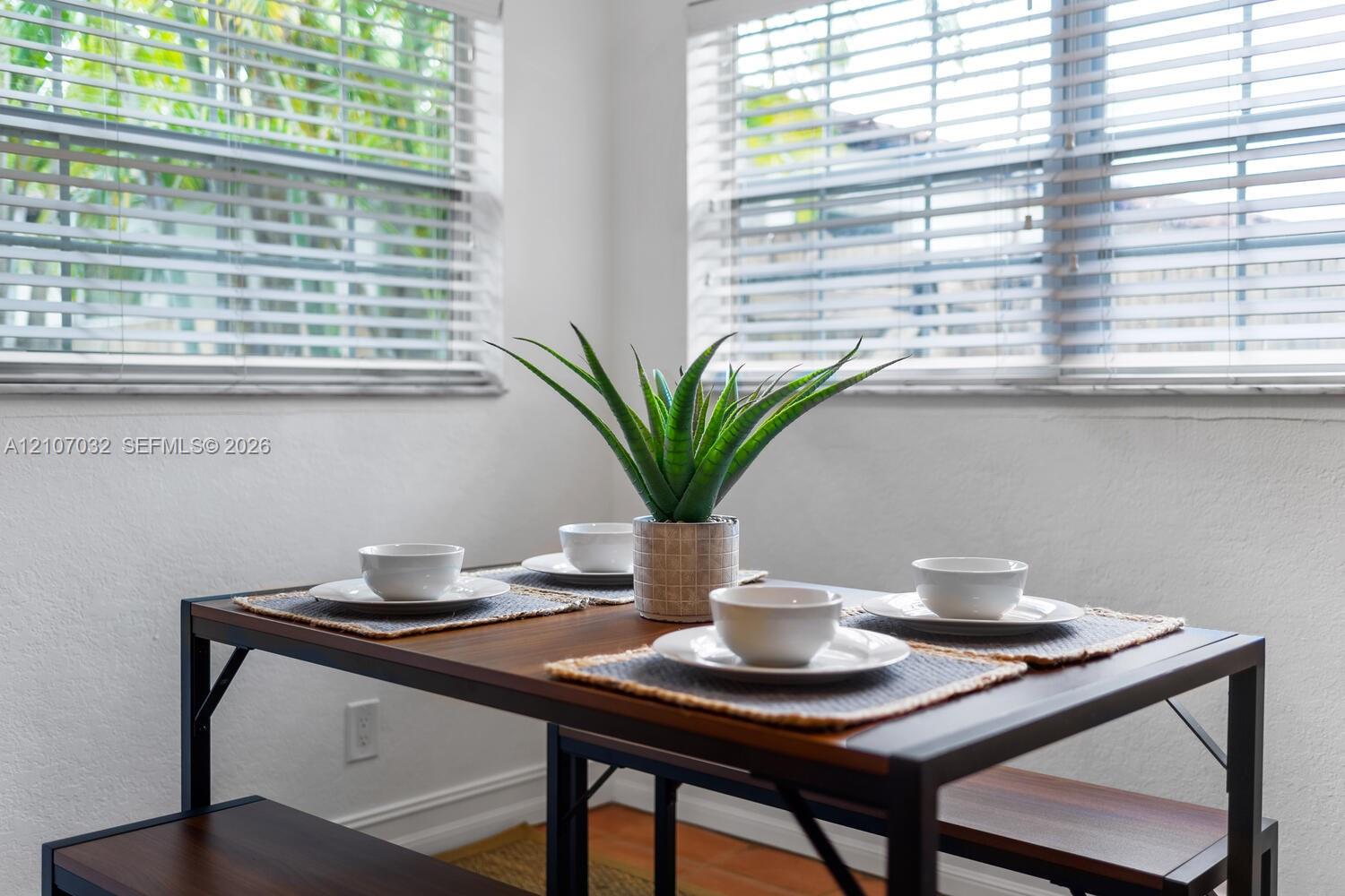Dual windows featuring horizontal blinds and wood-finish flooring