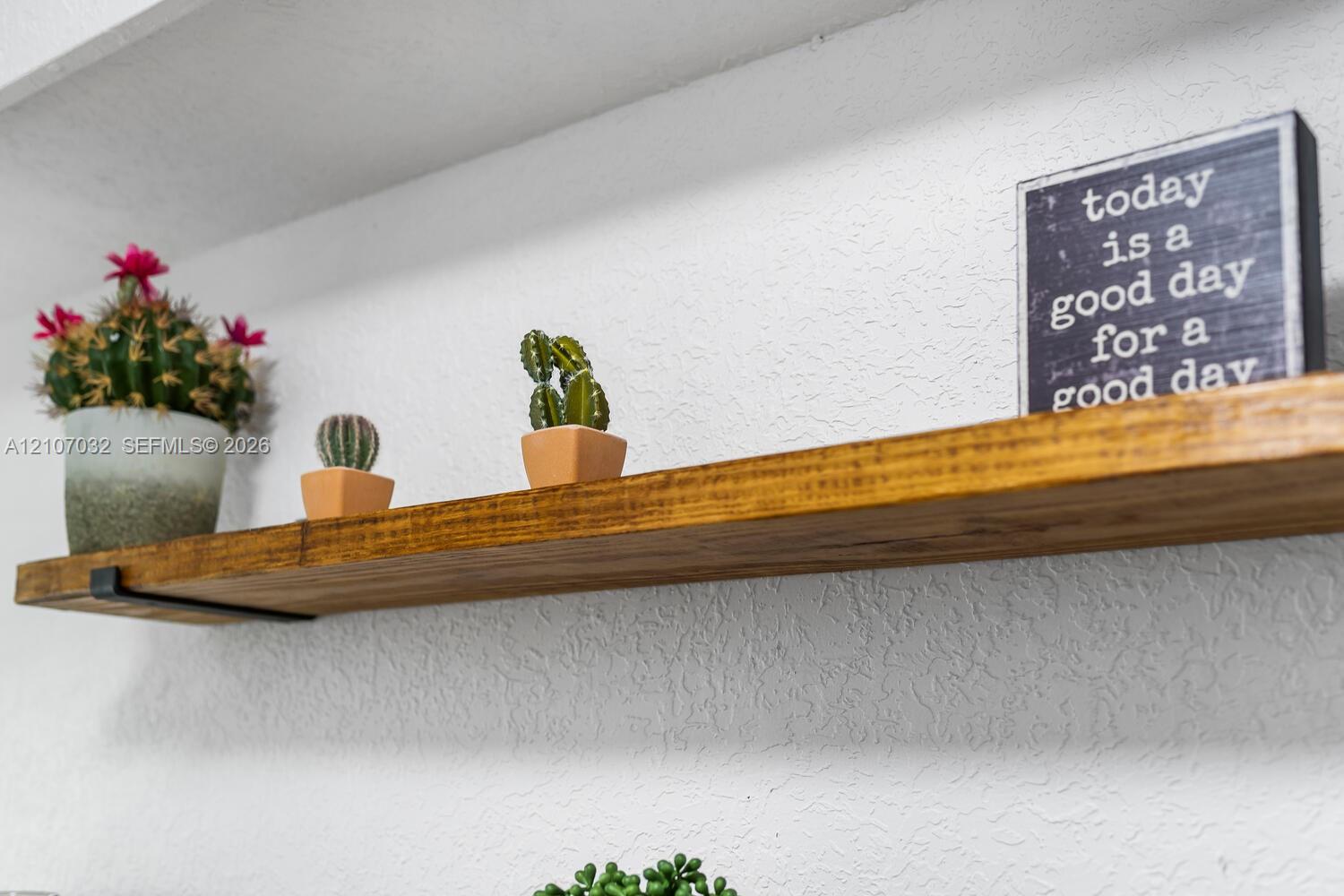 Wall-mounted solid wood floating shelving with matte black metal hardware brackets