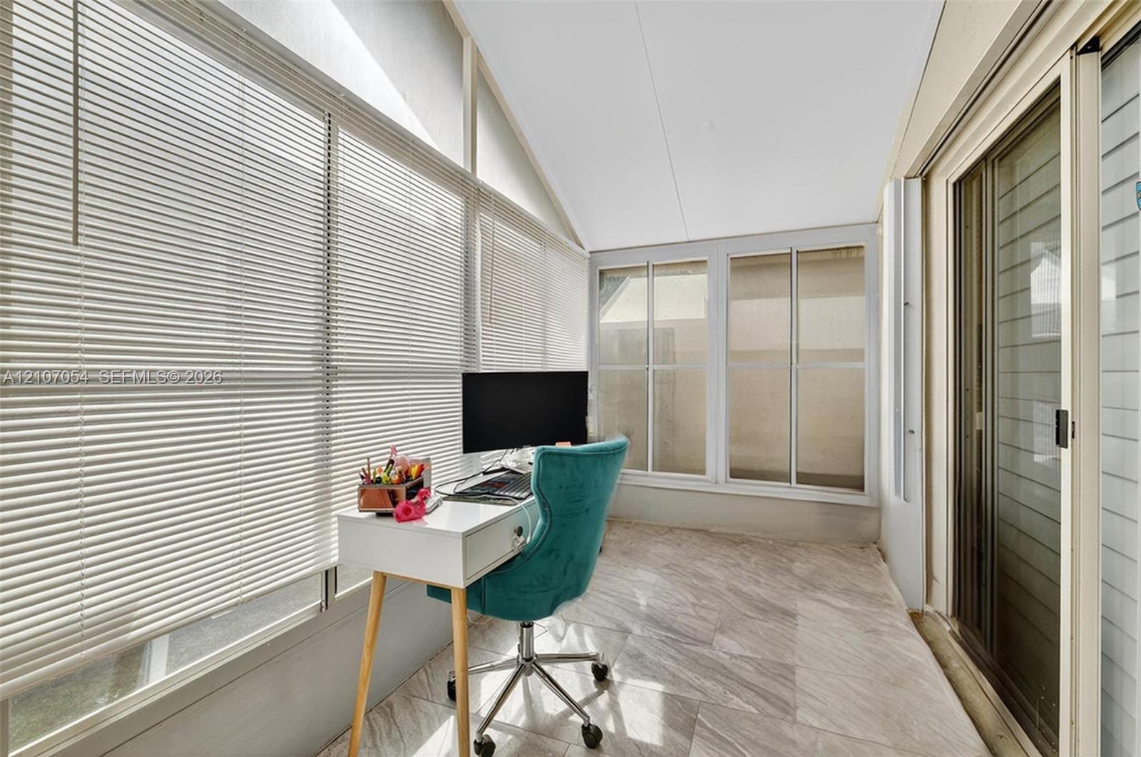 Florida Room featuring floor-to-ceiling windows, horizontal blinds, and large-format tile flooring with sliding glass door access