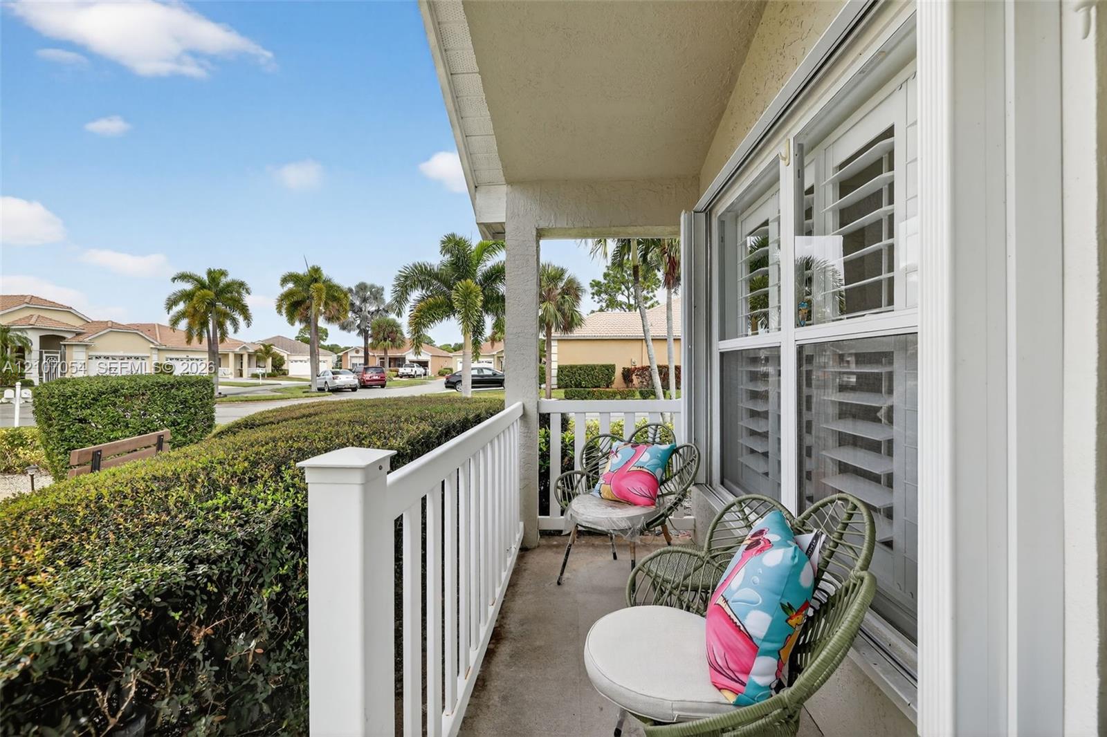 Covered entryway featuring a concrete floor, white picket-style railing, and windows with interior plantation shutters