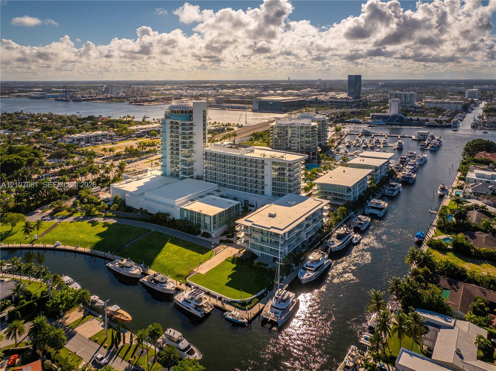 Aerial perspective of a multi-structure complex featuring deep-water canal access, private boat slips, extensive manicured lawn areas, and proximity to coastal waterways