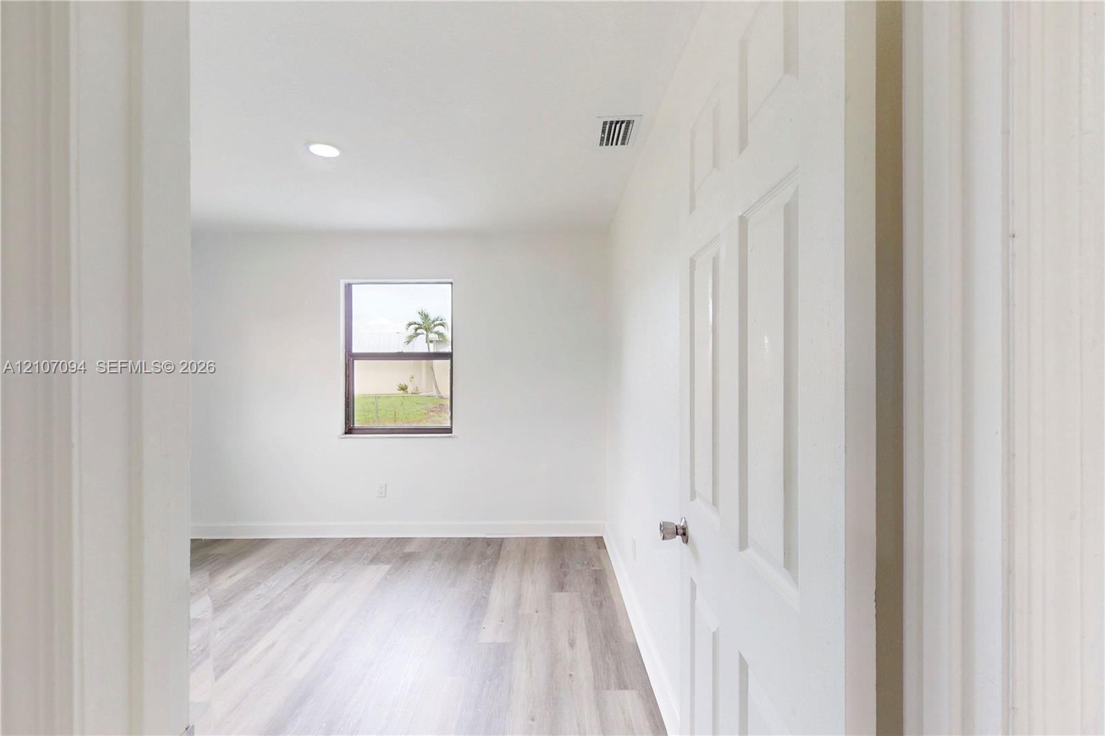 Interior room featuring wood-finish flooring, recessed lighting, and a single-panel window