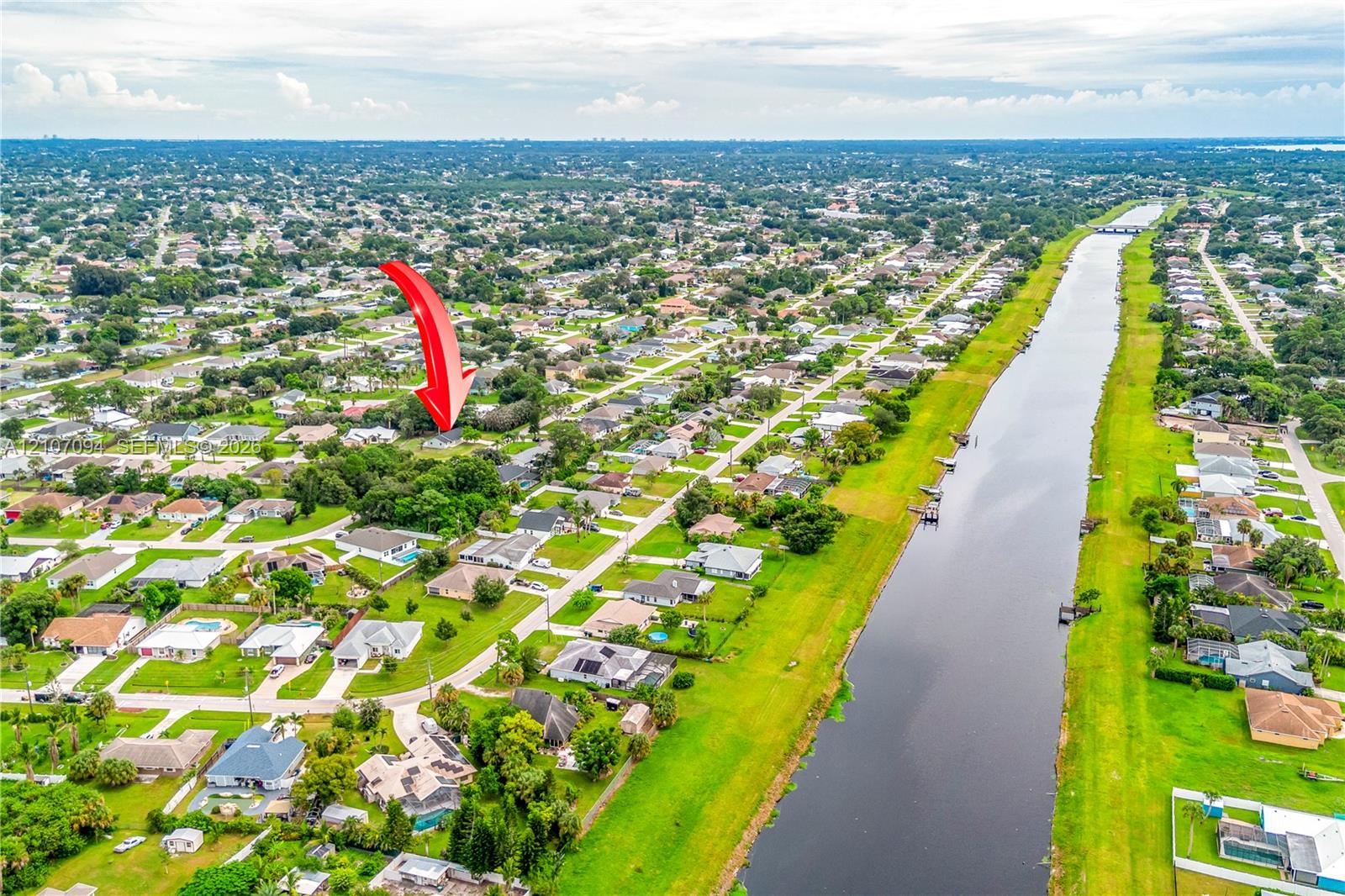 Aerial perspective of residential parcel featuring mature trees and canal frontage