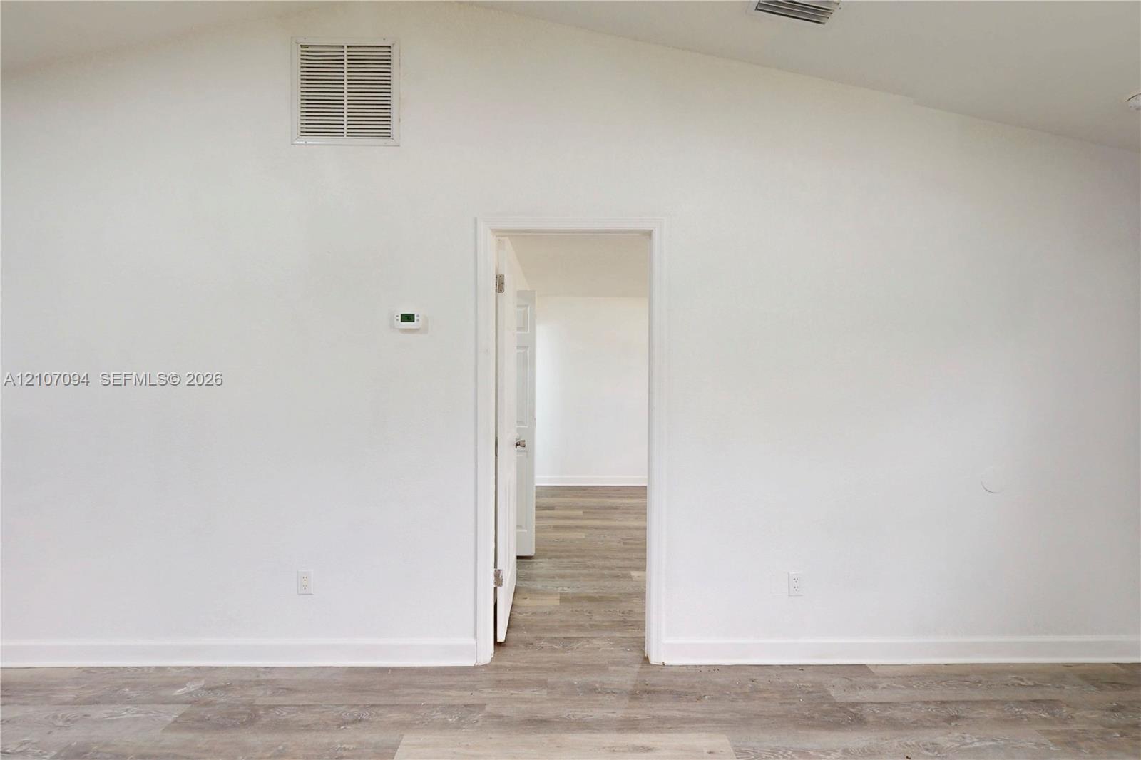 Vaulted ceiling featuring wood-finish flooring throughout