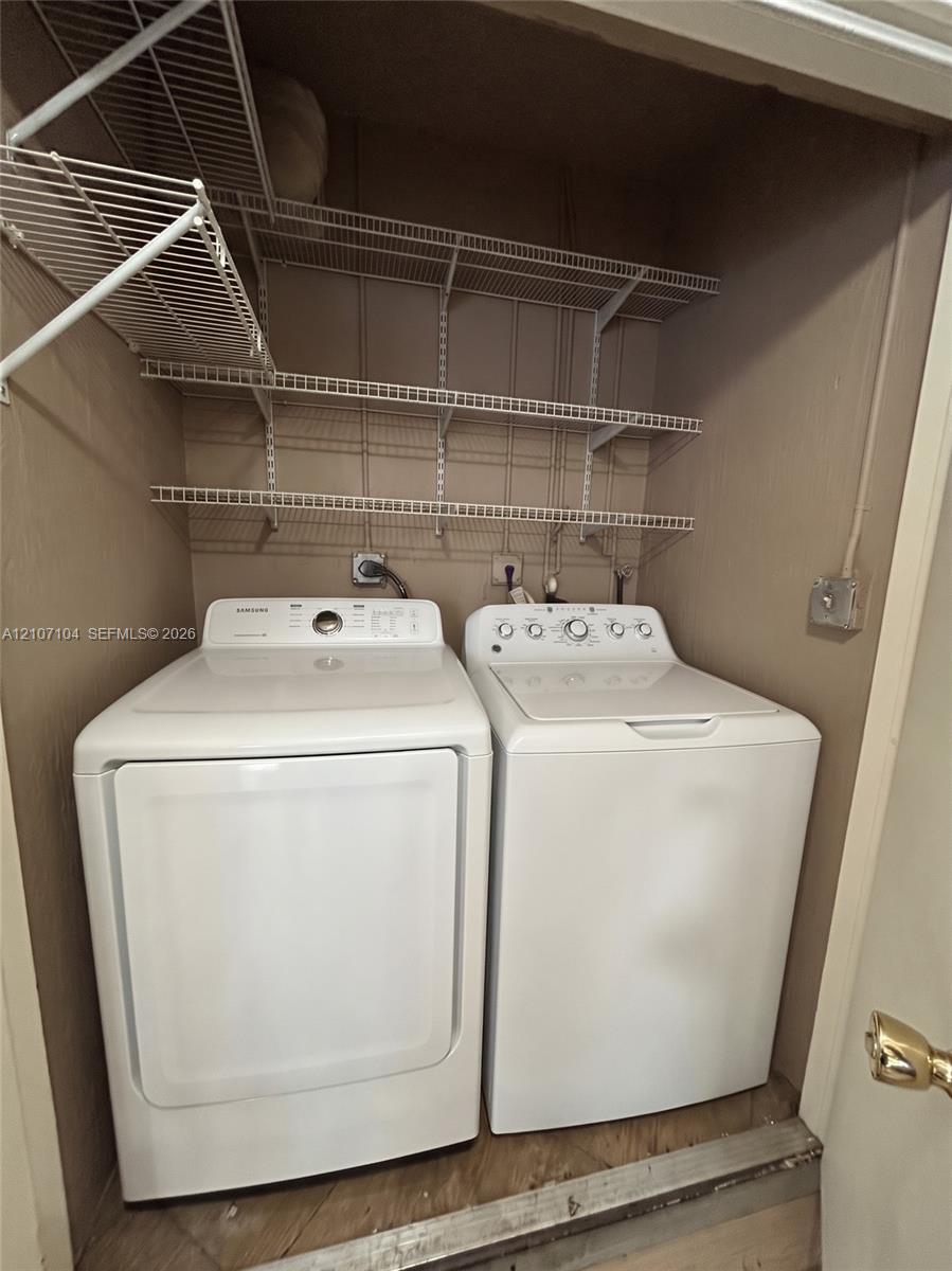 Laundry closet featuring three tiers of wire shelving and dedicated utility connections