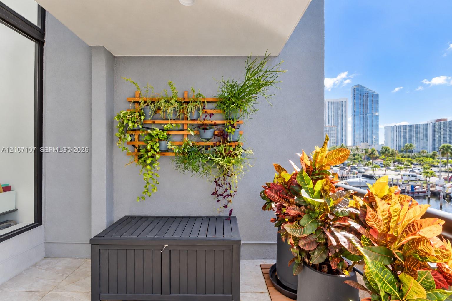 Private balcony featuring large-format tile flooring and a wall-mounted wooden trellis