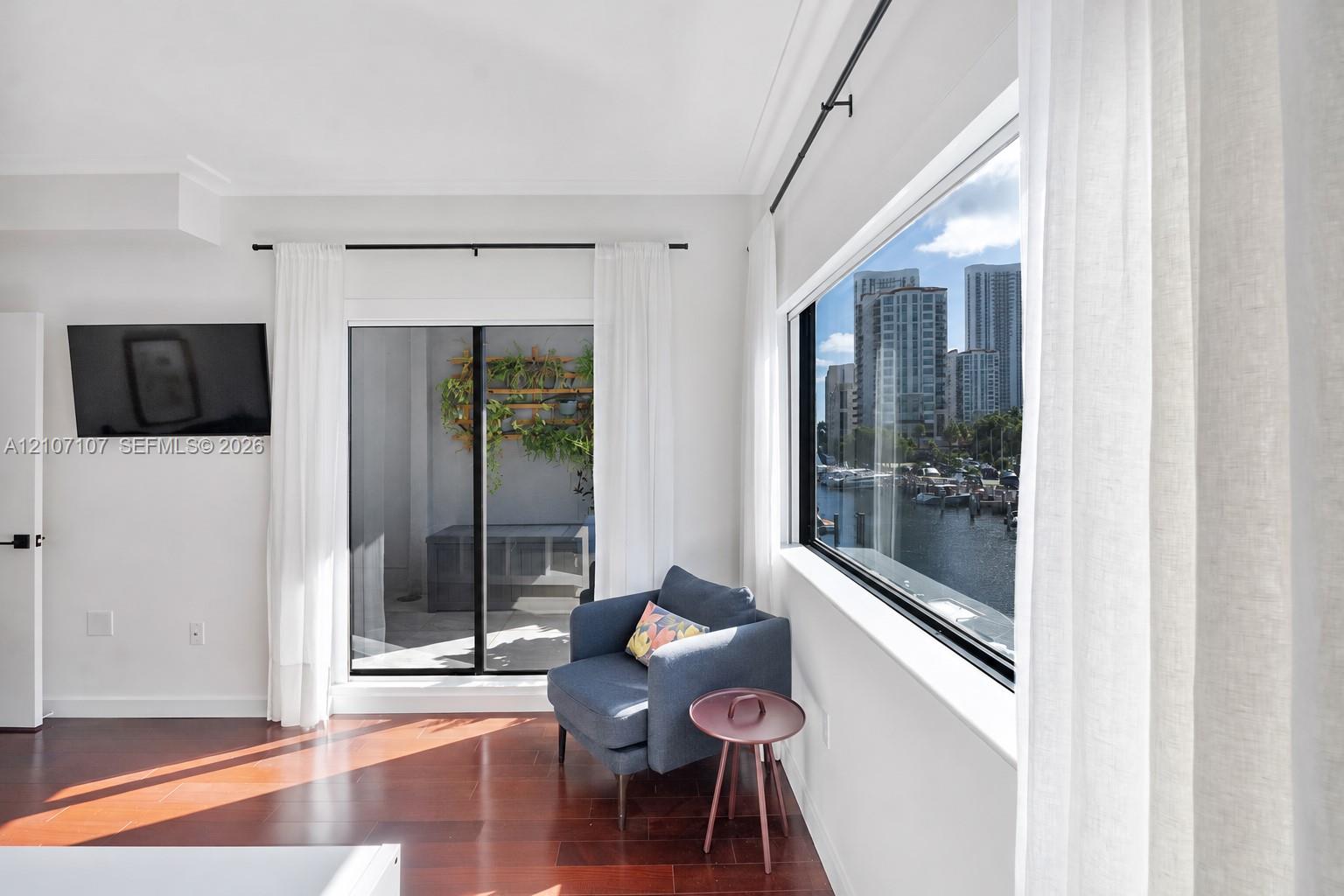 Wood-finish flooring, floor-to-ceiling windows, sliding glass door, and water scenery