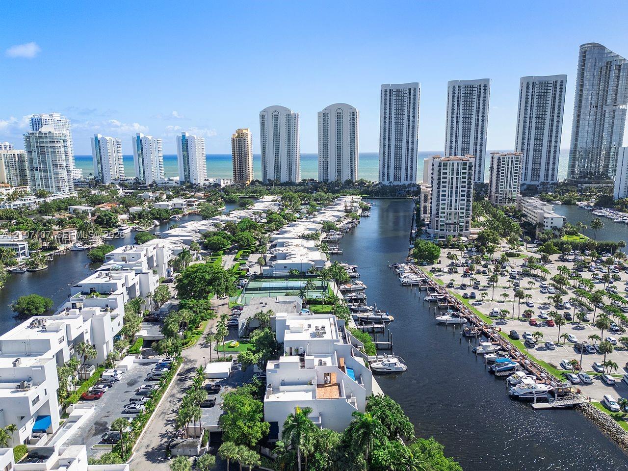 Waterfront multi-unit residential community featuring deep-water canal access, private boat slips, tennis courts, and tropical landscaping