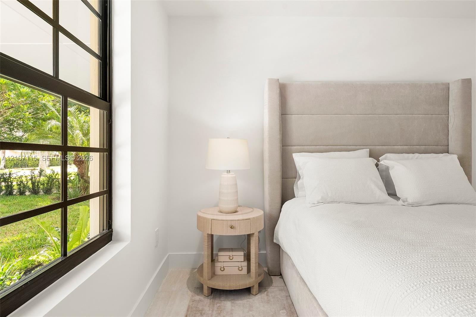 Large multi-pane window with dark metal framing and light-toned wood-finish flooring