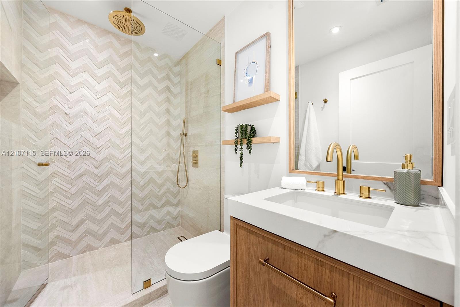Bathroom for Room 2 and 3 featuring a walk-in shower with chevron-patterned tile, frameless glass enclosure, rainfall showerhead, wood-finish vanity with stone countertop, and brass-tone hardware