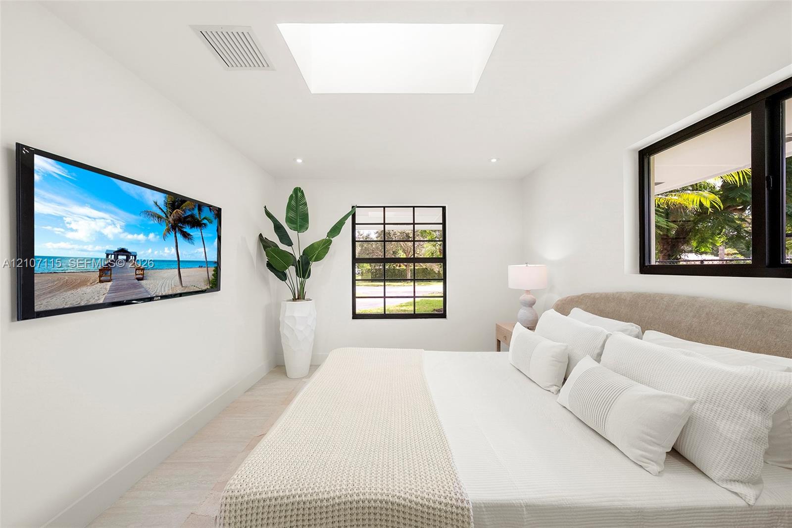 Skylight, black-framed windows, recessed lighting, and light-toned flooring
