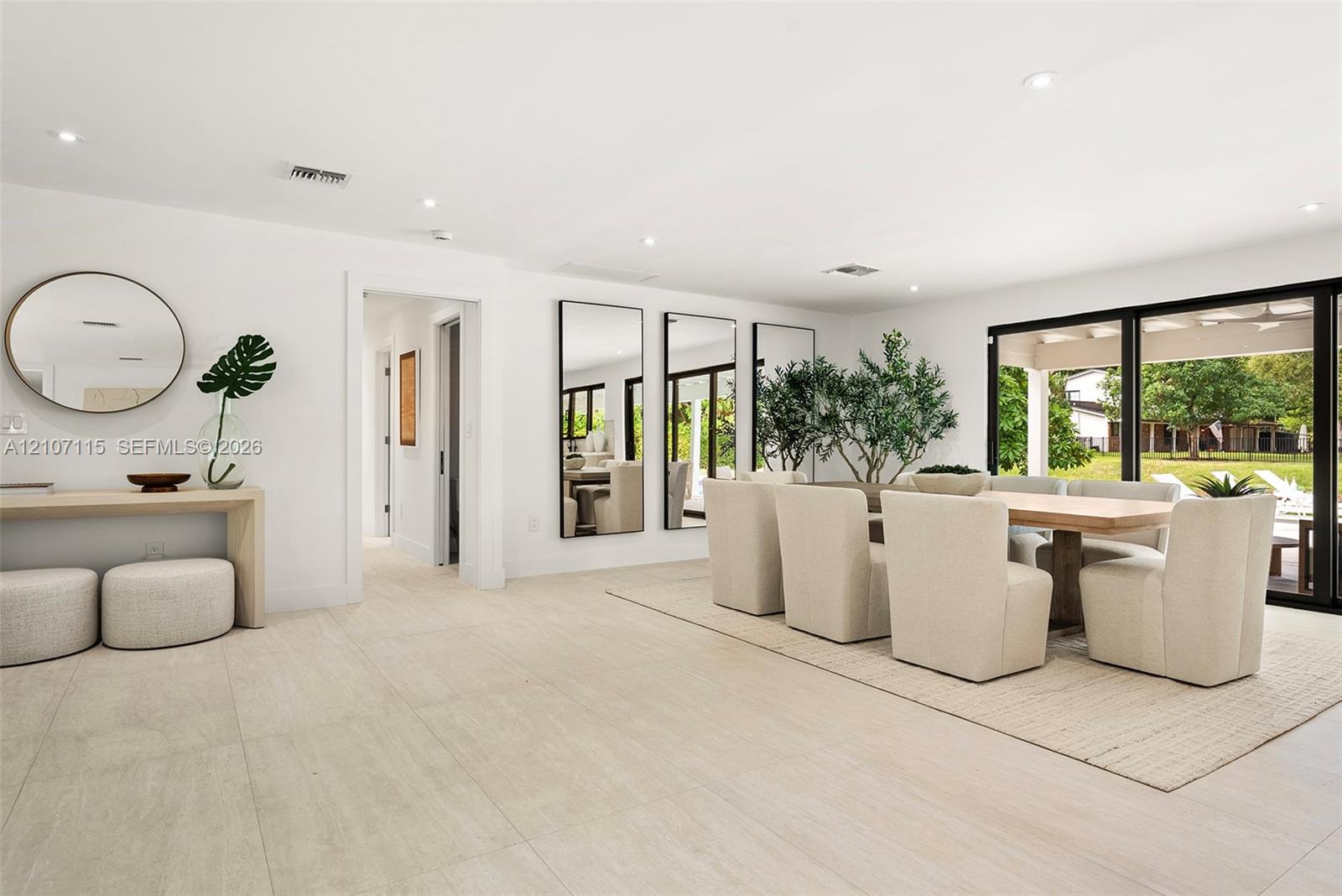 Large-format tile flooring, recessed ceiling lighting, and expansive glass sliding doors