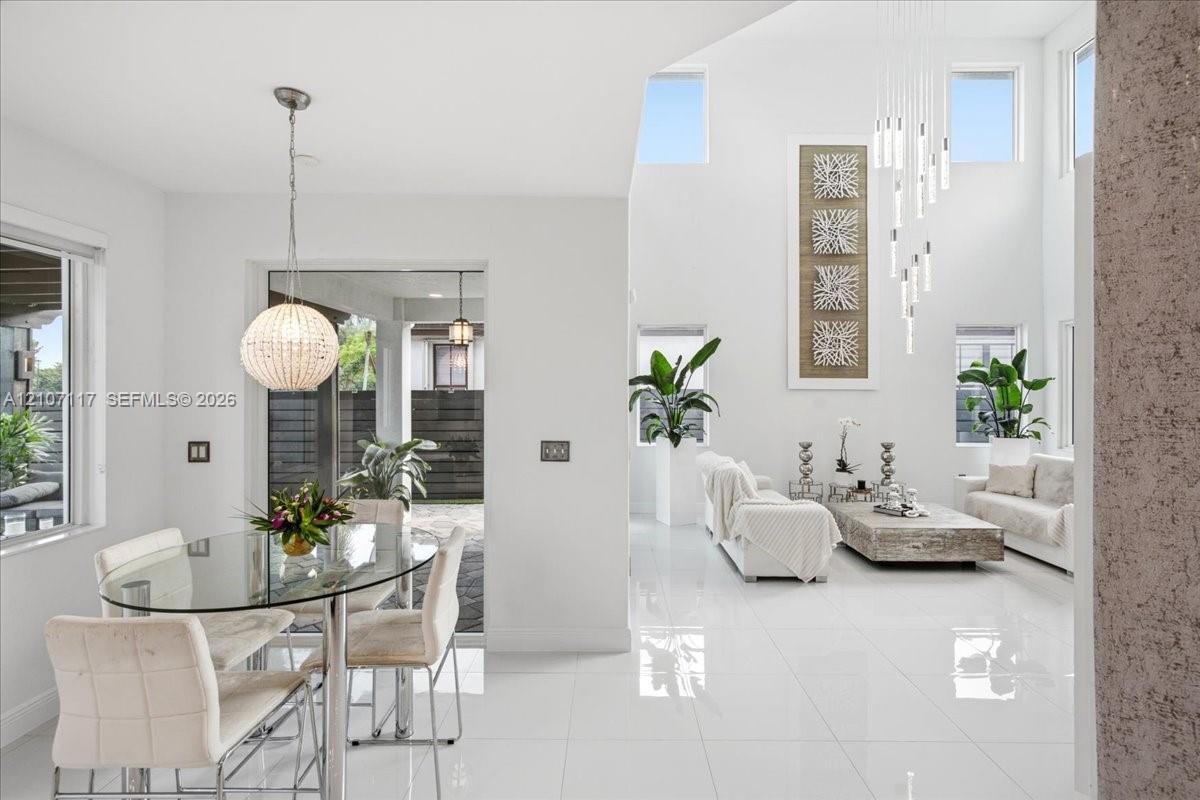 High-ceilinged interior featuring polished tile flooring, multi-level hanging pendant lighting, and abundant natural light provided by clerestory windows