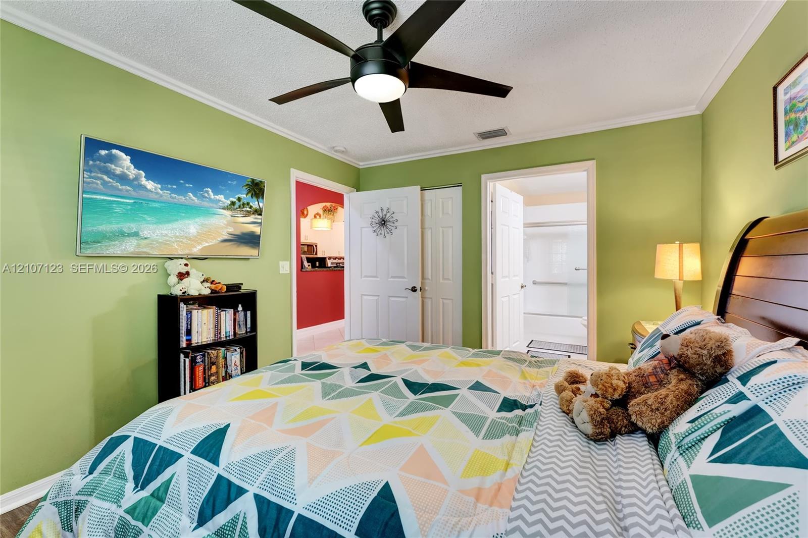 Room featuring a black multi-blade ceiling fan with integrated lighting, dual-panel interior doors, and crown molding