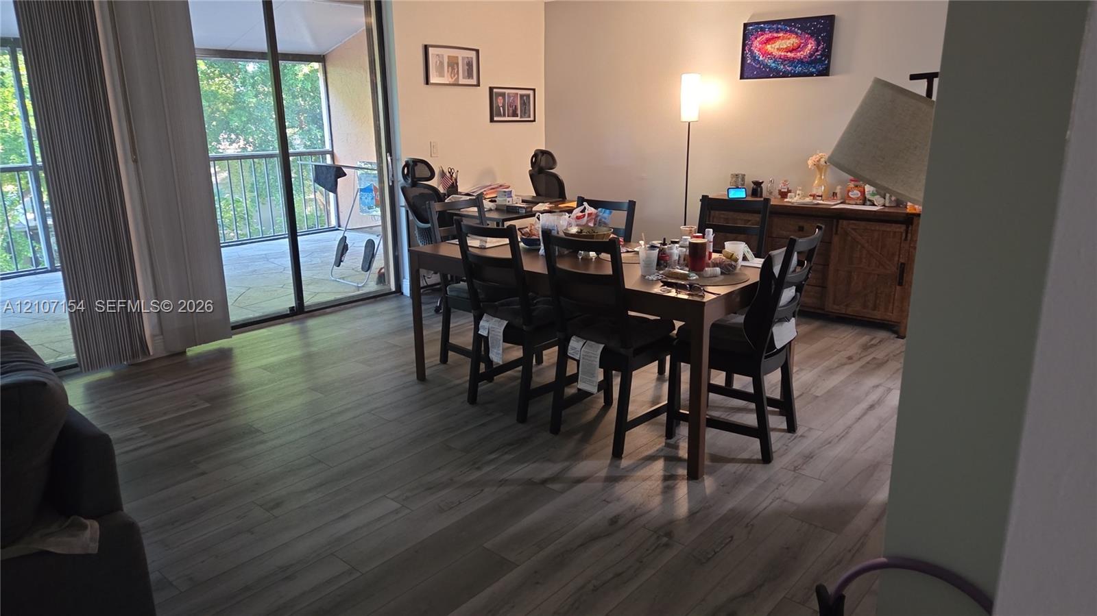 Wood-finish flooring, sliding glass patio door, and metal balcony railing
