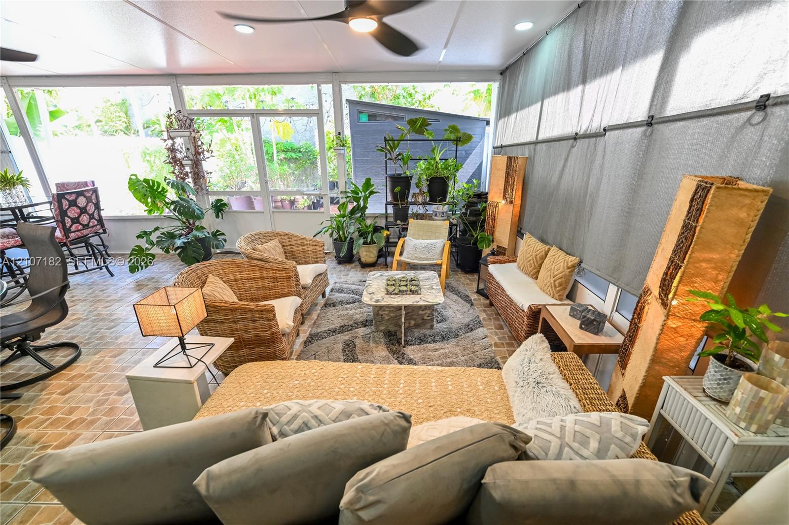 Screened-in patio featuring decorative tile flooring, ceiling-mounted fan, recessed lighting, and large screen panels