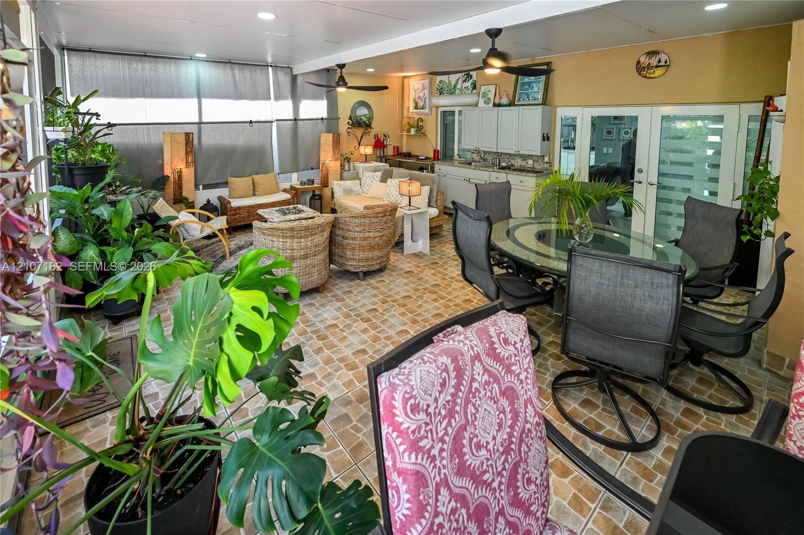 Enclosed patio featuring tile flooring, built-in cabinetry, recessed lighting, and dual ceiling fans