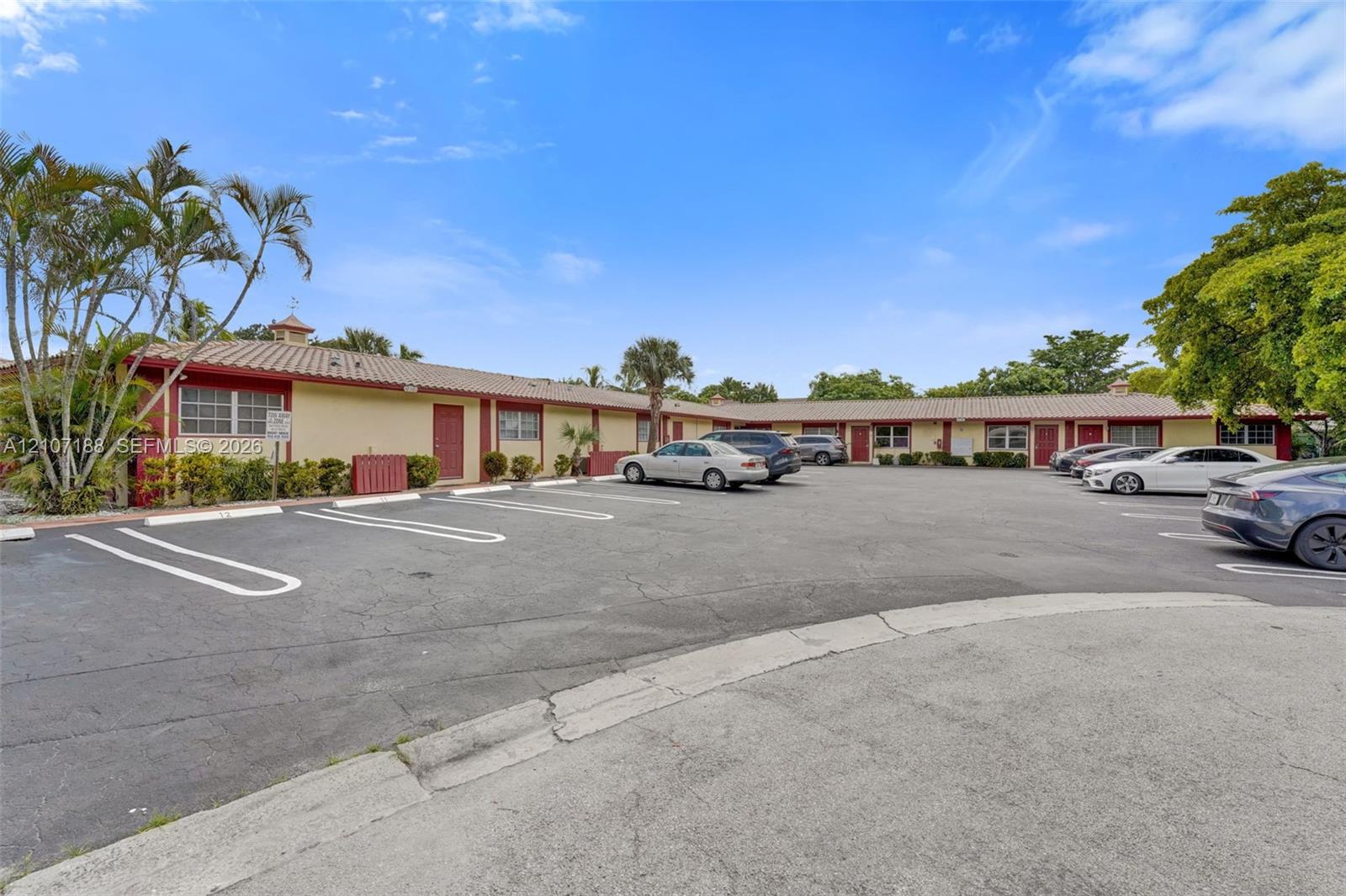 Single-story exterior featuring a tile roof, stucco siding, and dedicated surface parking