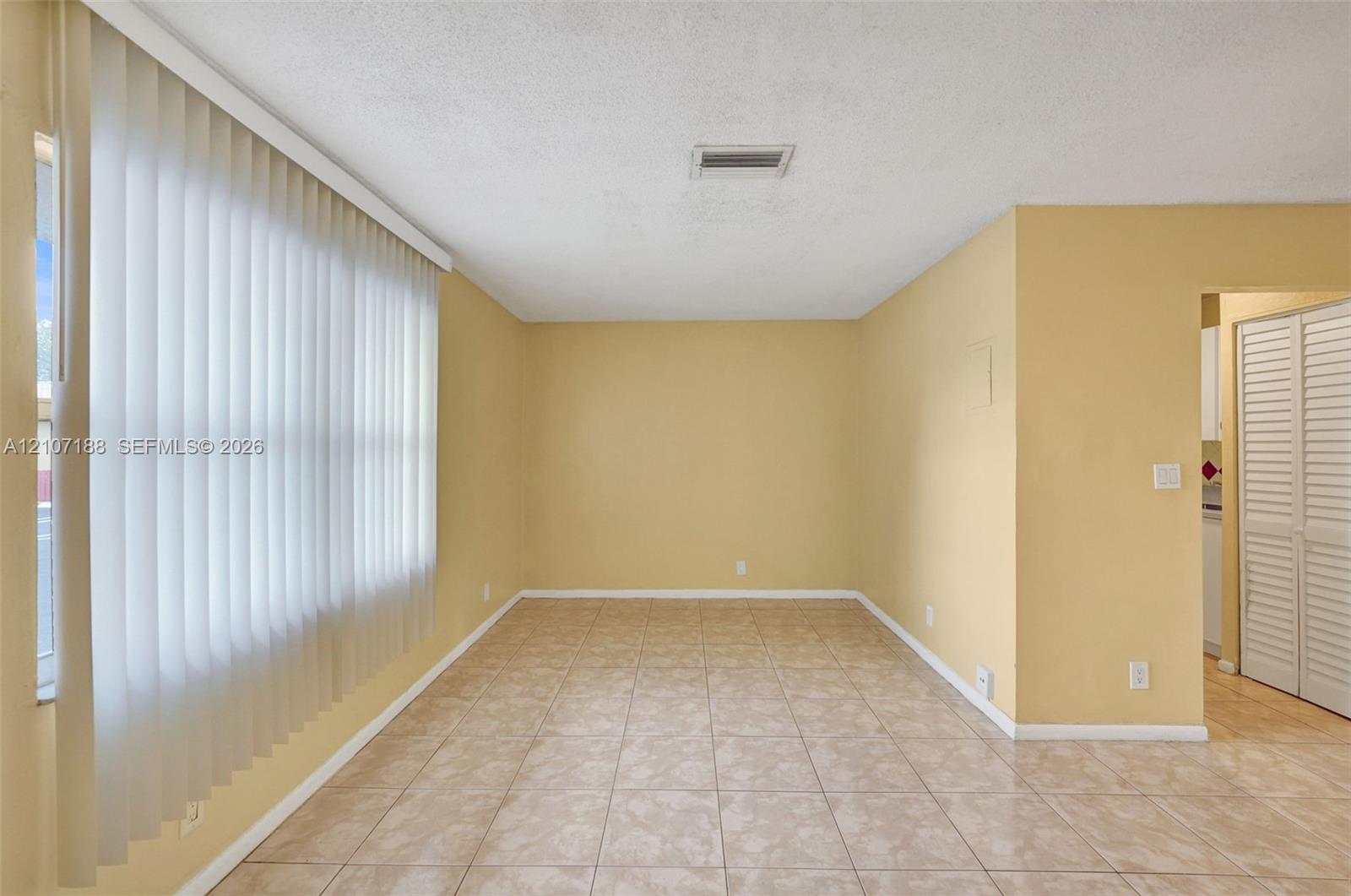 Tile flooring, vertical window blinds, and louvered closet doors