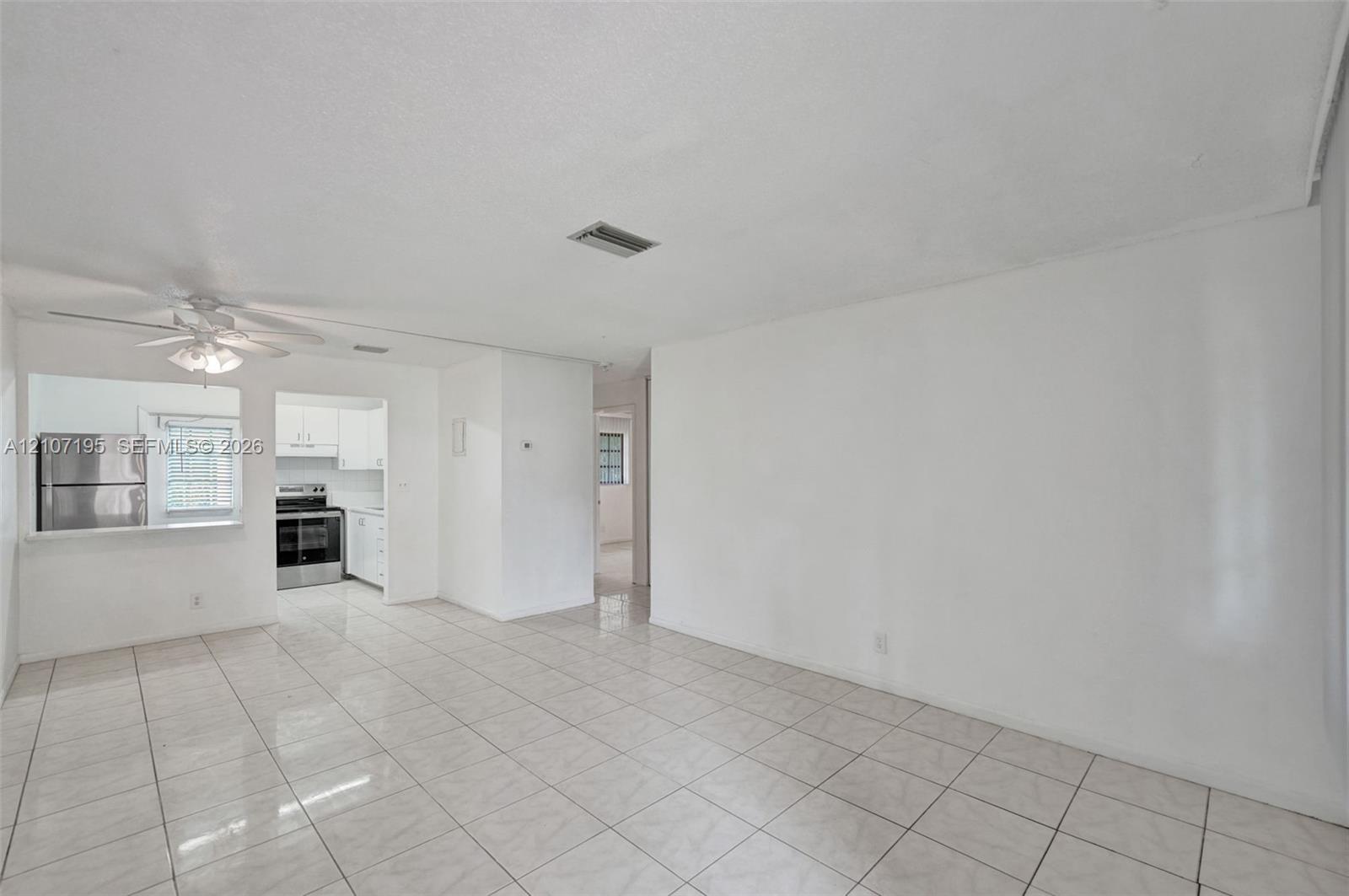 Interior space featuring light-toned tile flooring, recessed ceiling lighting, and a white ceiling fan