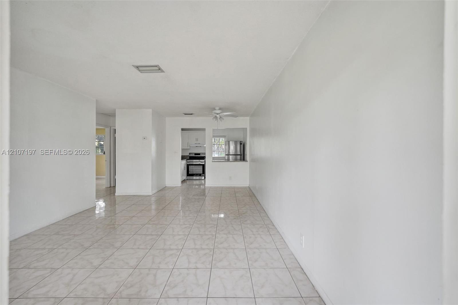 Interior space featuring neutral wall tones, large-format tile flooring, and a ceiling-mounted fan