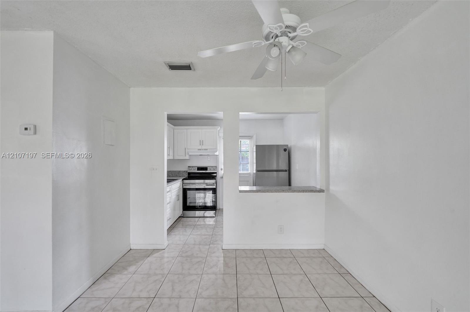 Interior space featuring tile flooring and a ceiling-mounted light fixture with a fan