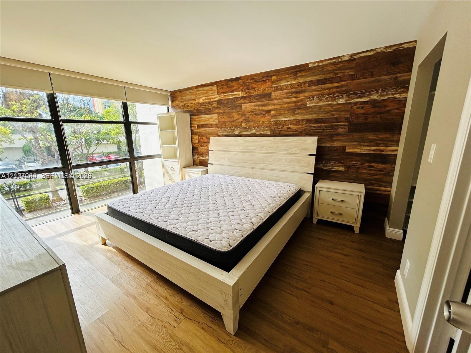Floor-to-ceiling windows, wood-finish wall paneling, and wood-finish flooring
