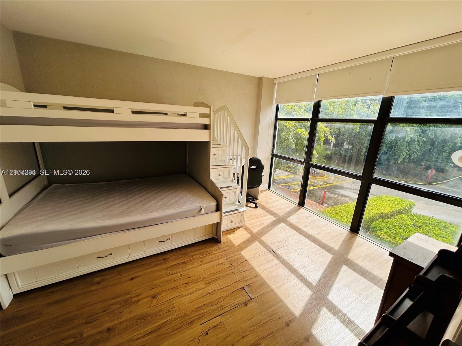 Floor-to-ceiling windows featuring black grid frames and wood-finish flooring