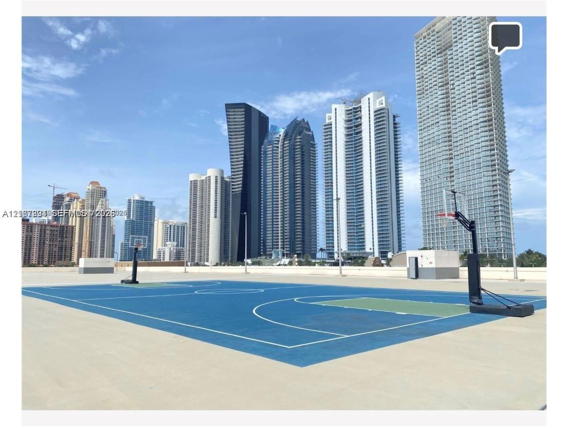 Outdoor sport court featuring a hard surface, painted markings, and two basketball hoops