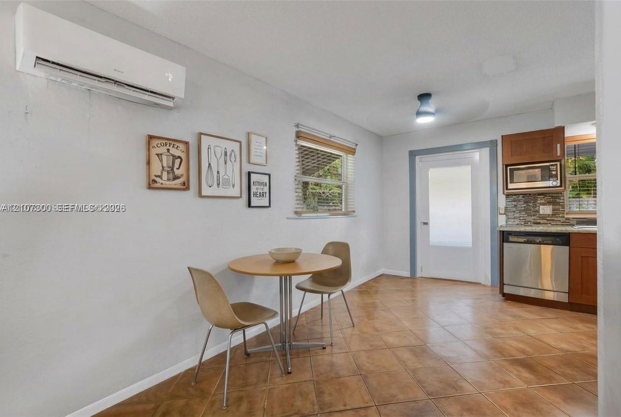 Wall-mounted mini-split HVAC unit, tile flooring, built-in stainless steel dishwasher, built-in microwave, and wood-finish cabinetry