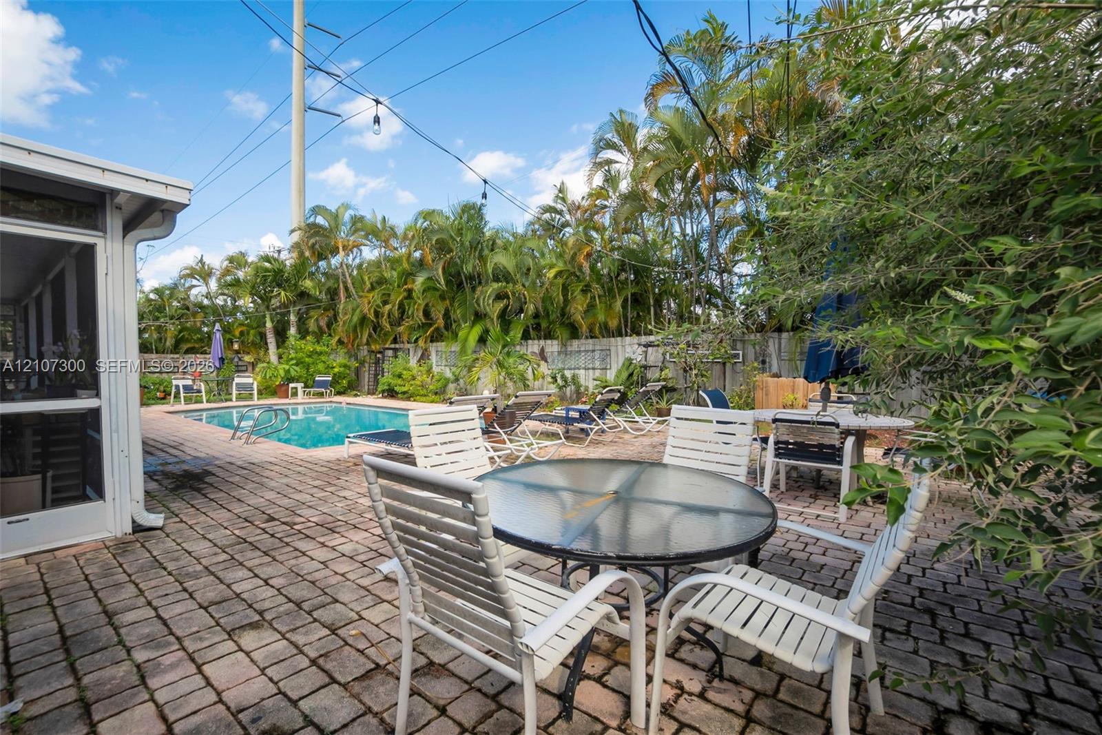 Outdoor space featuring a brick-paved patio, in-ground swimming pool, and privacy fencing