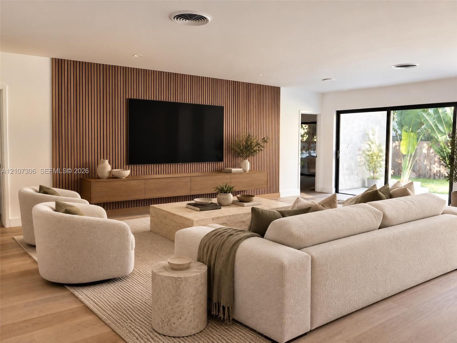 Vertical slat wood feature wall with a built-in wall-mounted media console, wood-finish flooring, and expansive sliding glass doors Vertical slat wood feature wall with a built-in wall-mounted media console, wood-finish flooring, and expansive sliding glass doors