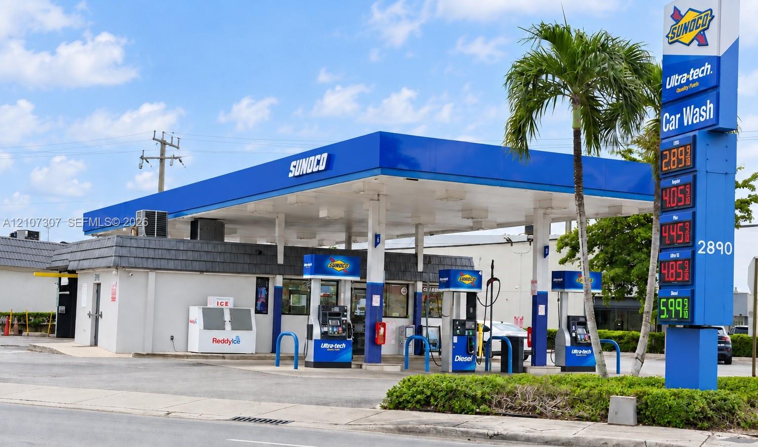 Commercial property featuring a multi-pump fuel canopy, detached convenience store structure, integrated car wash facility, and high-visibility price signage