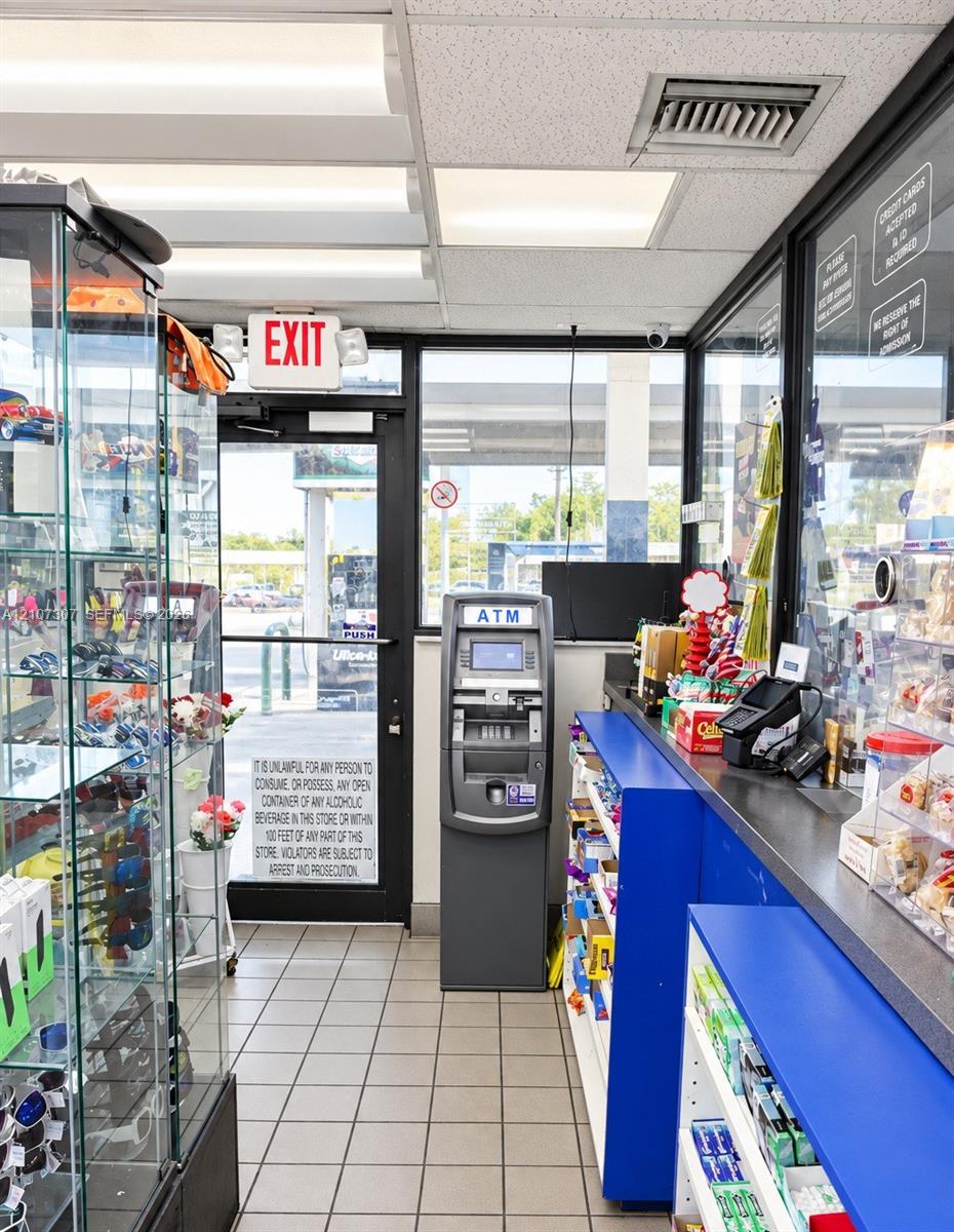 Commercial space featuring tile flooring, floor-to-ceiling glass paneling, built-in service counter, and overhead fluorescent lighting