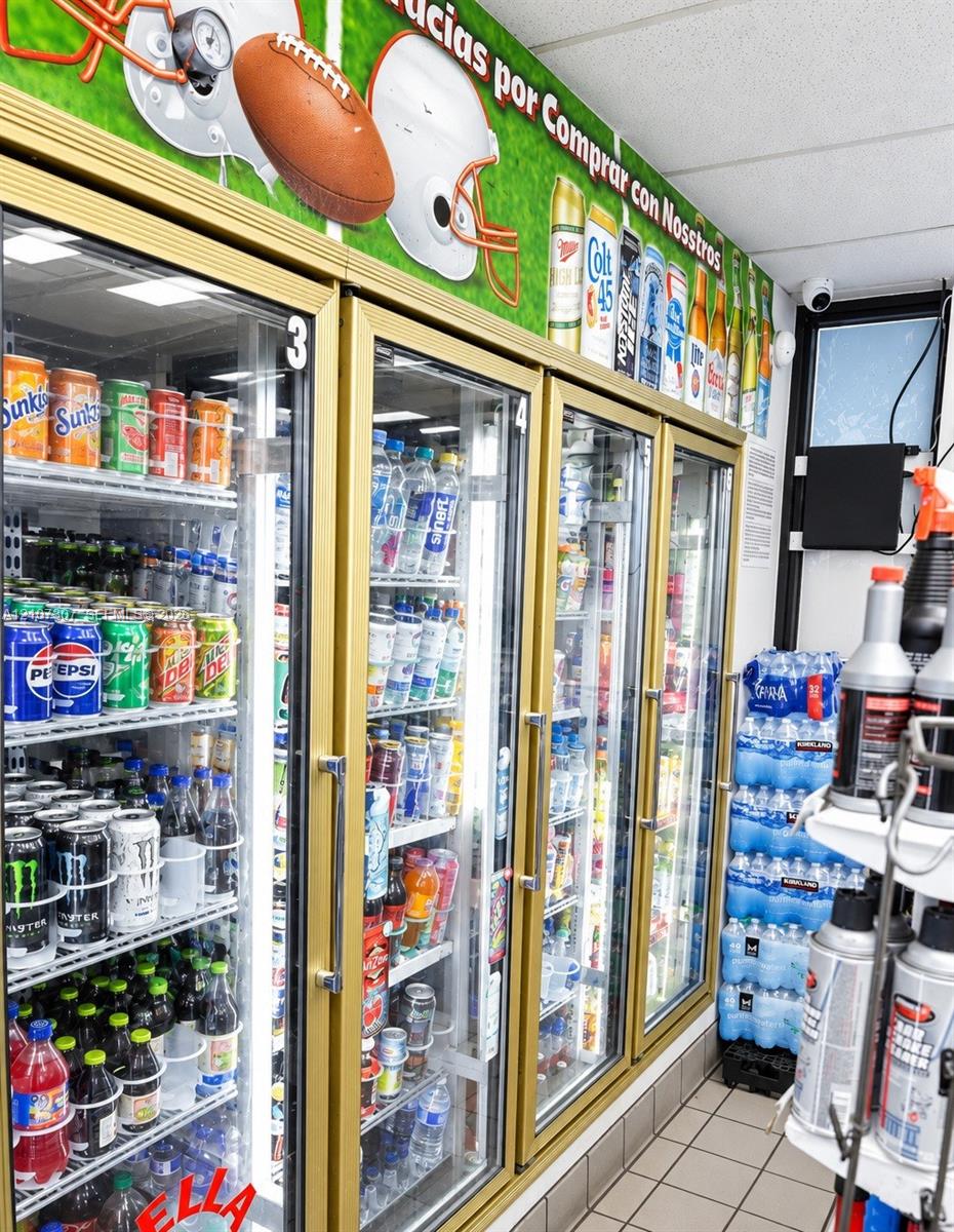 Multi-door commercial refrigeration units with gold-tone frames and interior LED lighting, complemented by tile flooring
